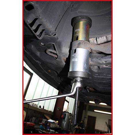 Werkzeug unter einem Auto zur Reparatur, silberfarbenes Werkzeug mit langem Hebel.